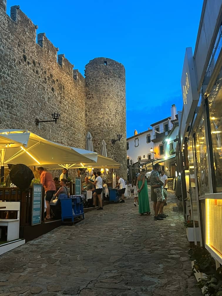 Restaurants in the town of Tossa de Mar at dusk along the walls of the Tossa de Mar old town.