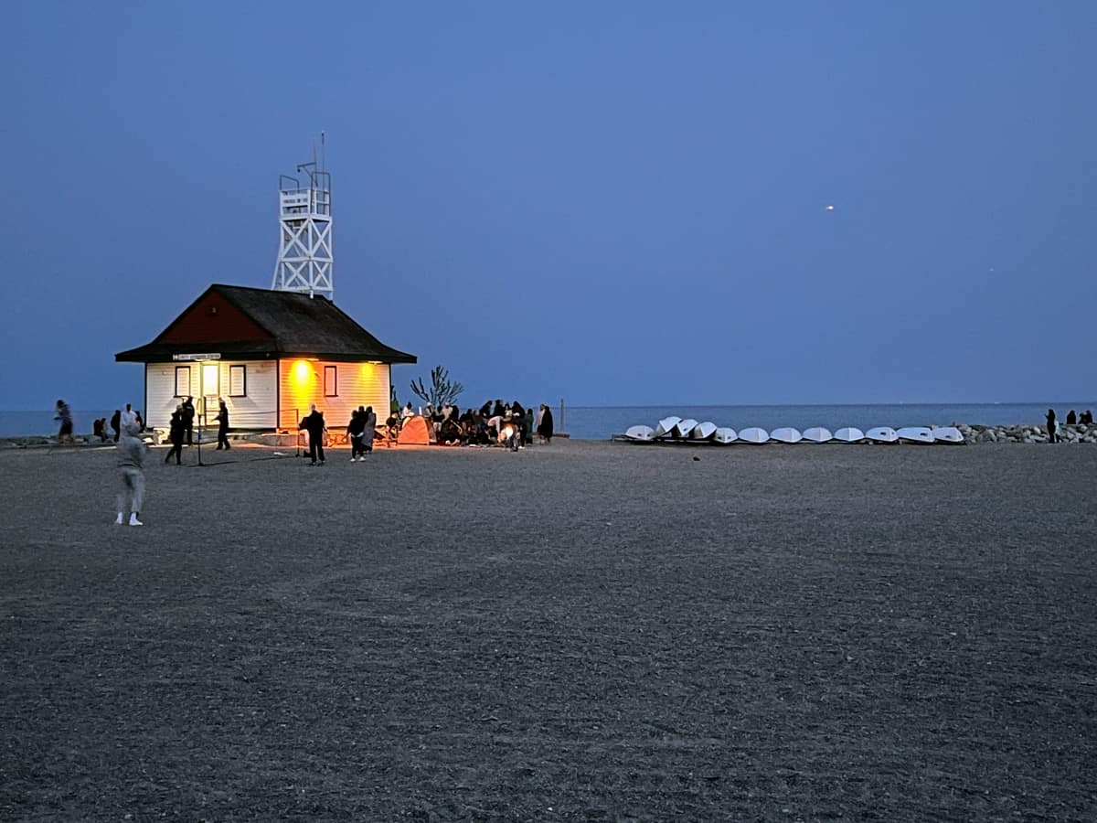 Leuty Lifeguard on Woodbine Beach station at dusk with Lake Ontario in the background.