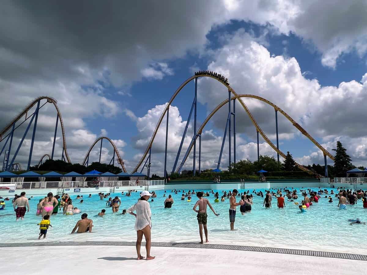 Large pool at Canada's Wonderland's waterpark, Splash Works with roller coasters in the background.