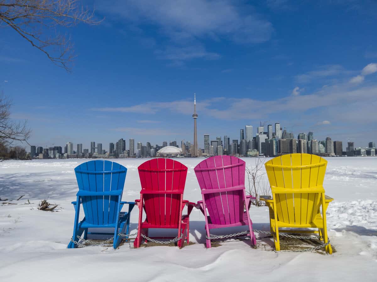 View of Toronto city skyline in winter seen from the Toronto Islands with colourful chairs.