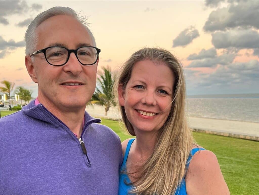 Close up of couple smiling in front of the beach at sunset in Cancun, Mexico.