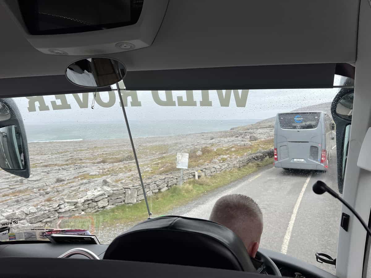 View of the Irish Coast from the front seat of a tour bus while driving along the Wild Atlantic Way close to Galway, Ireland. Another tour bus can be seen in front on the narrow Irish roads.