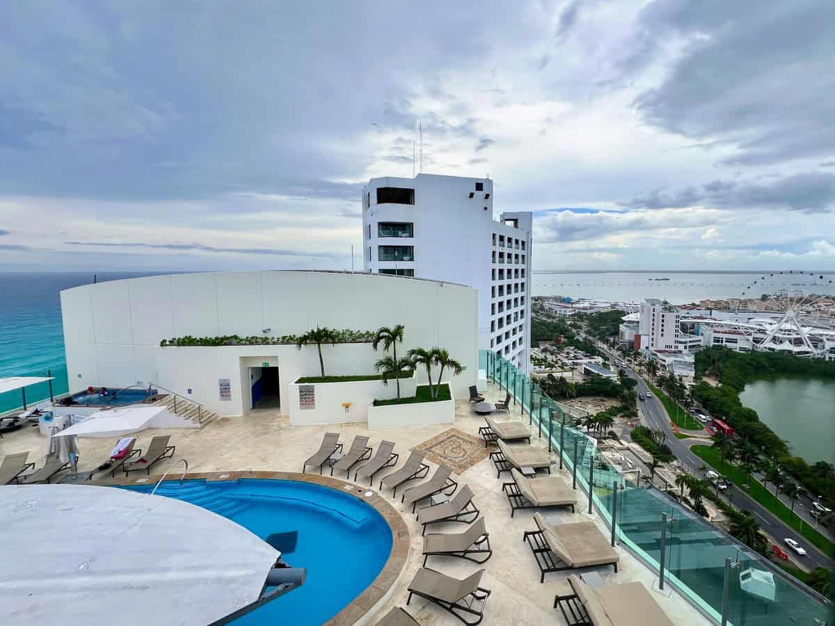 Panoramic view from the Beach Palace Resort’s rooftop, overlooking the Caribbean Sea and Nichupté Lagoon. The rooftop pool is surrounded by sun loungers, offering breathtaking ocean and city views in every direction.