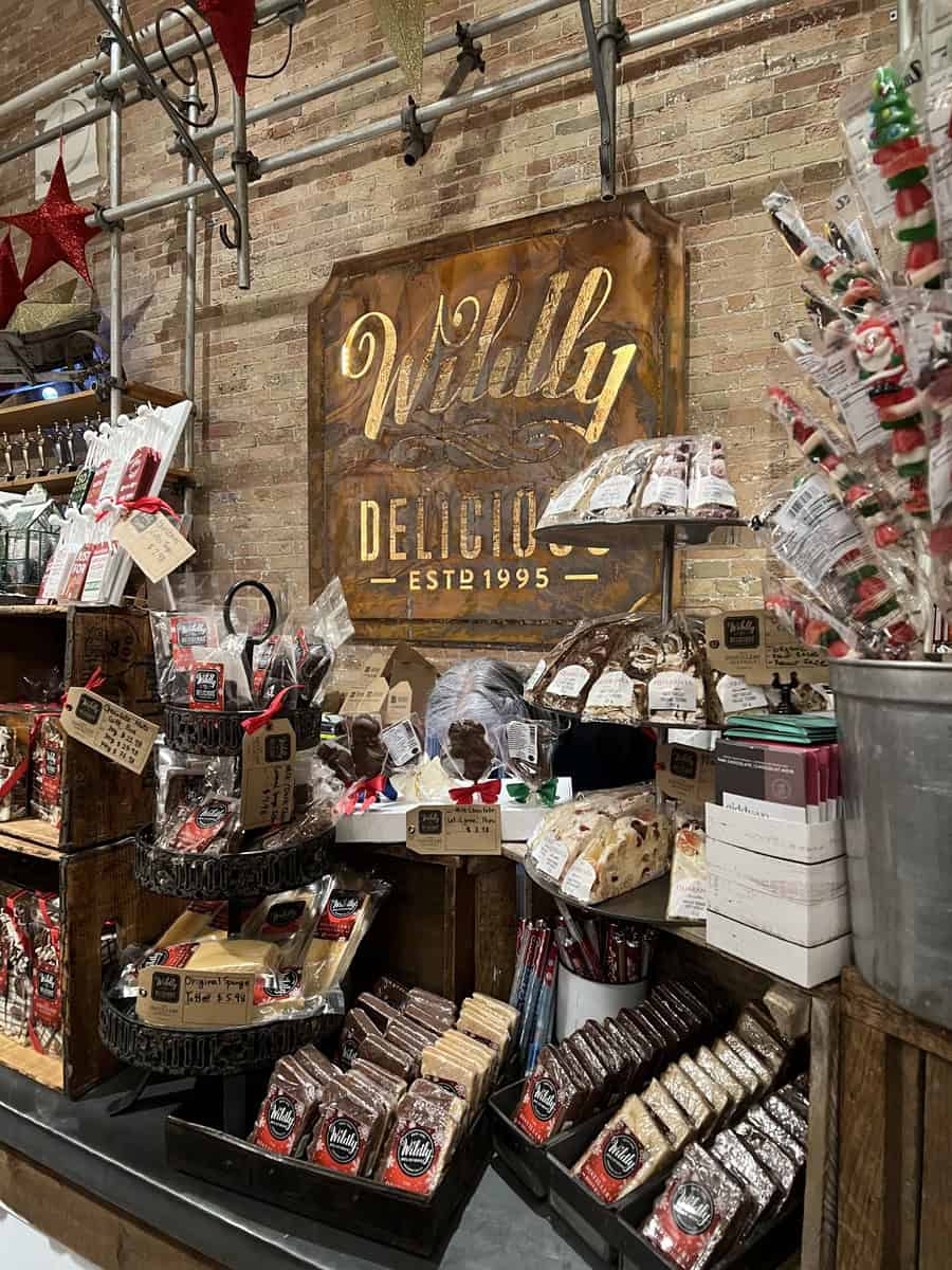 Holiday-themed display inside Wildly Delicious in Toronto’s Distillery District, featuring gourmet treats, festive decor, and artisanal snacks in a rustic brick-and-wood setting.