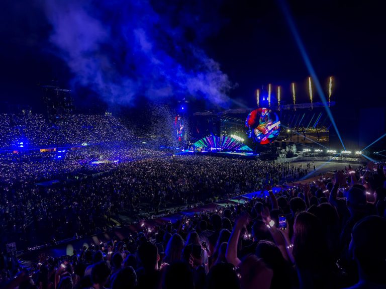 Fans in Toronto watch the Coldplay concert at Rogers Stadium at Downsview airport. Stands are full with fans watching the concert on a summer evening.