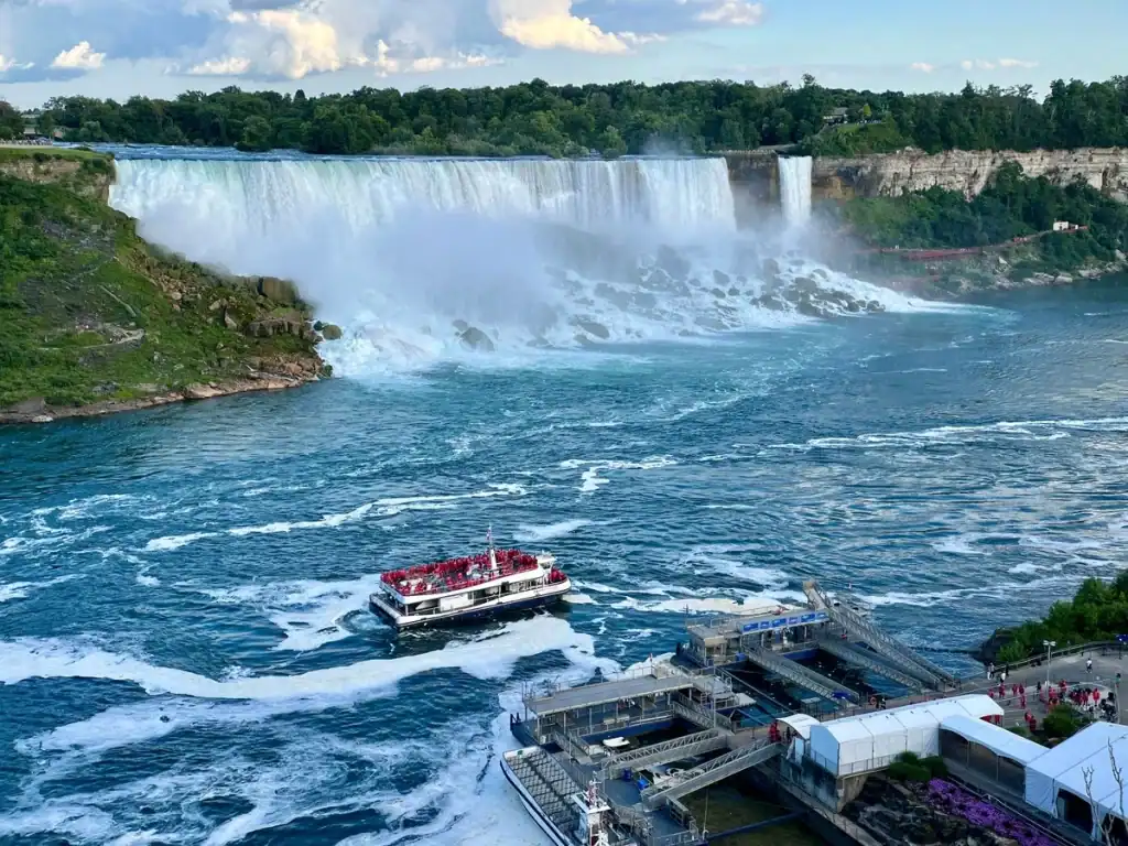 Overhead view of the Hornblower Boat ride in Niagara Falls Canada as the boat leaves the dock to see the falls. Boat is packed with tourists dressed in red ponchos.