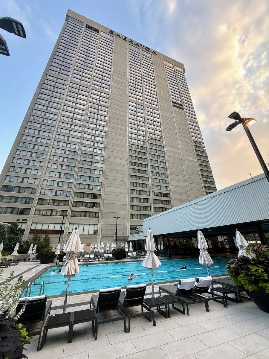 The Sheraton Hotel in downtown Toronto towers over a huge indoor/outdoor pool surrounded by loungers on a early summer morning. Ideal for visitors looking for a hotel with a pool and when travelling with kids.