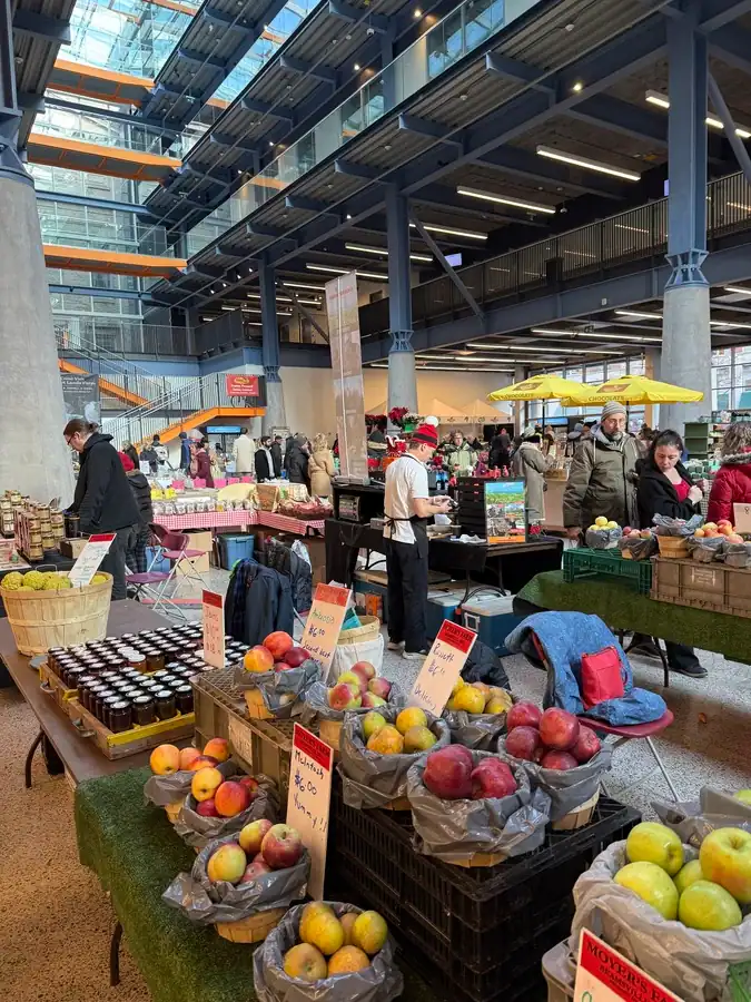 Farmers market stalls display apples, honey and various fruits and vegetables indoors at the North Market of St Lawrence Market in Toronto.
