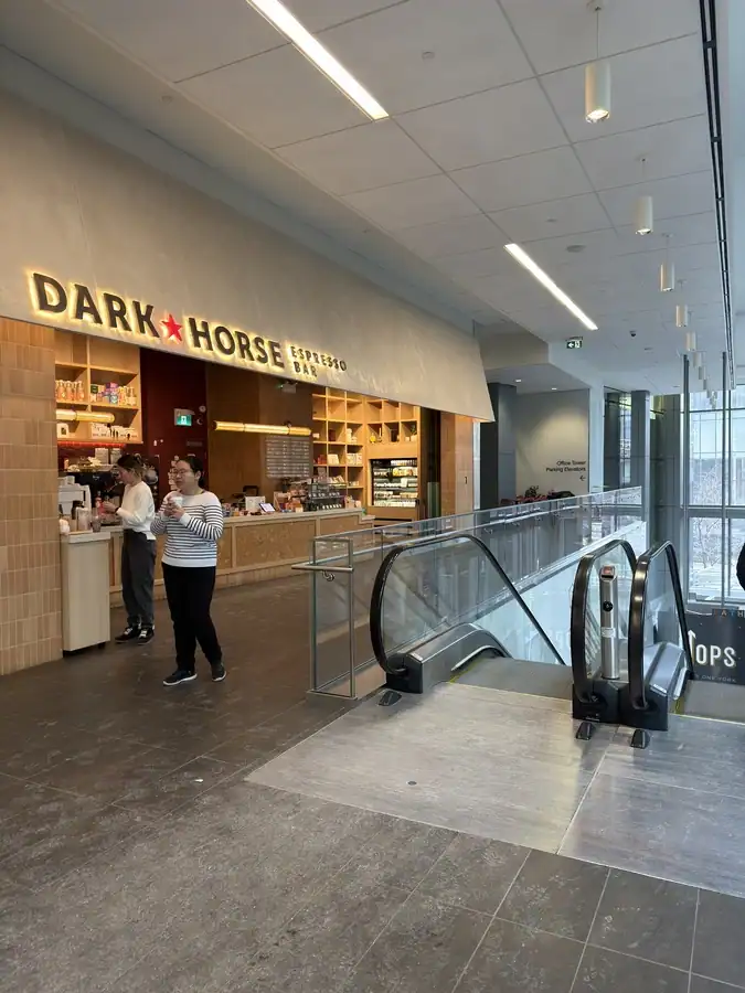 The cafe Dark Horse Espresso Bar serves customers coffee in Toronto's PATH system. The cafe is at the top of a set of escalators.