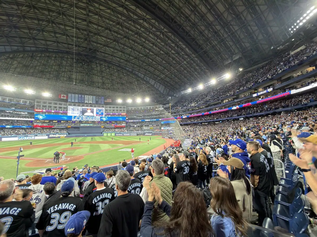 Standing fans cheer on the Toronto Blue Jays under a closed roof at the Rogers Centre.